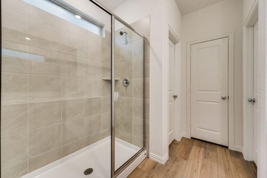 Bathroom with hardwood / wood-style floors and an enclosed shower