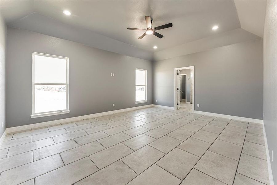 Empty room with ceiling fan and light tile patterned floors