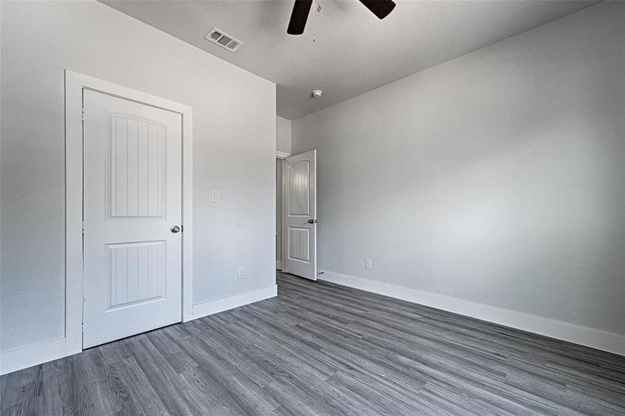 Unfurnished bedroom with ceiling fan and dark hardwood / wood-style flooring