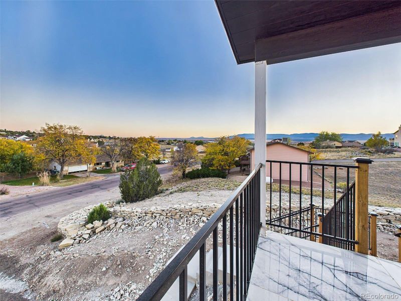 Expansive elevated view from the covered porch capturing neighborhood scenery and mountain backdrop. Expansive elevated view from the covered porch capturing neighborhood scenery and mountain backdrop.