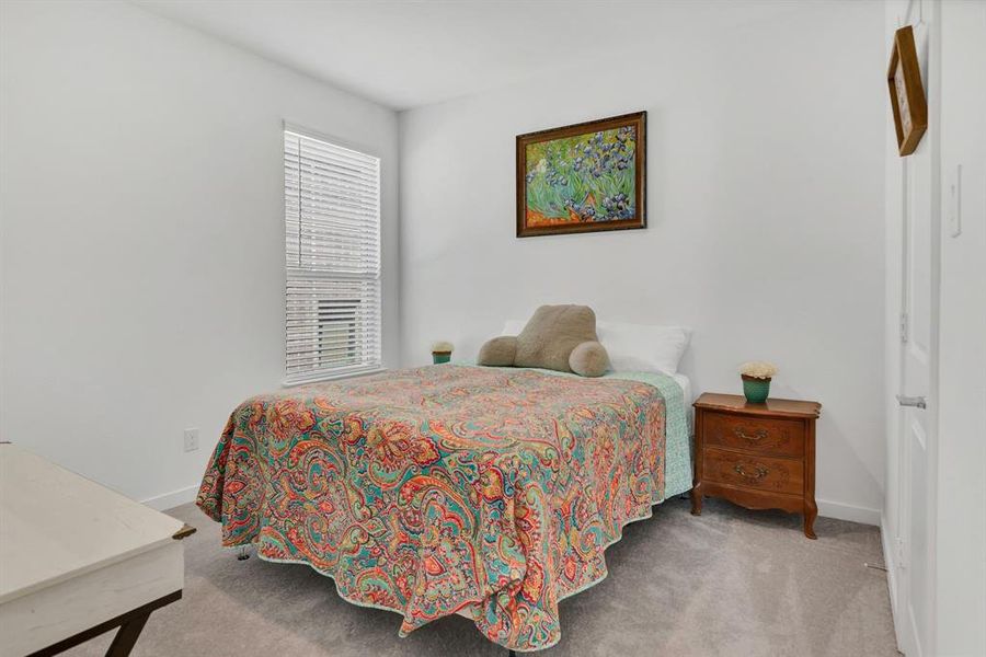 Bedroom featuring light colored carpet and baseboards