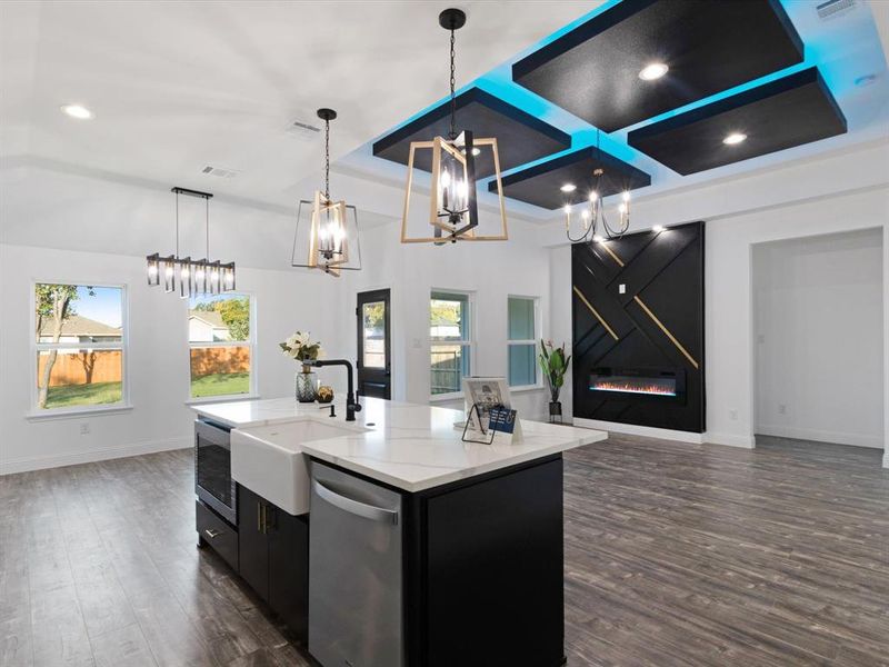 Kitchen with a center island with sink, dark hardwood / wood-style floors, dishwasher, pendant lighting, and sink