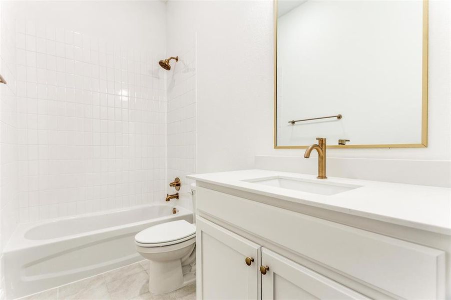 Bathroom featuring tile patterned flooring, toilet, vanity, and shower / bathtub combination