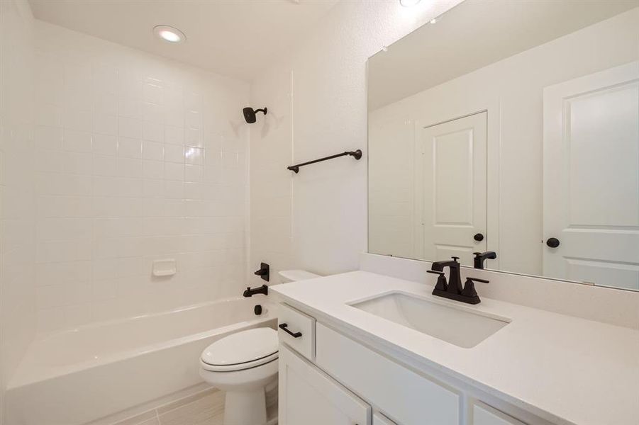 Full bathroom featuring vanity, toilet, and tiled shower / bath