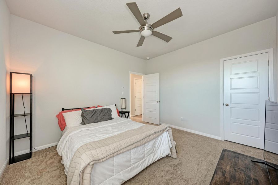 Bedroom with light carpet and a ceiling fan