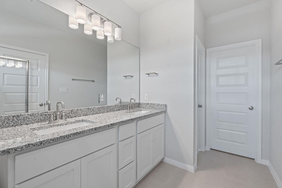 Full bathroom featuring double vanity and tile patterned flooring