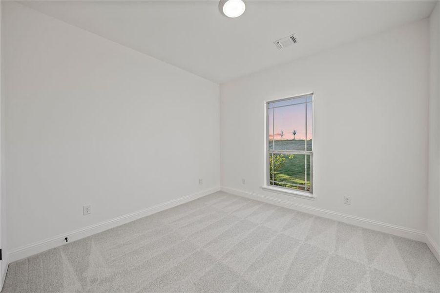 Spare room with baseboards and light colored carpet