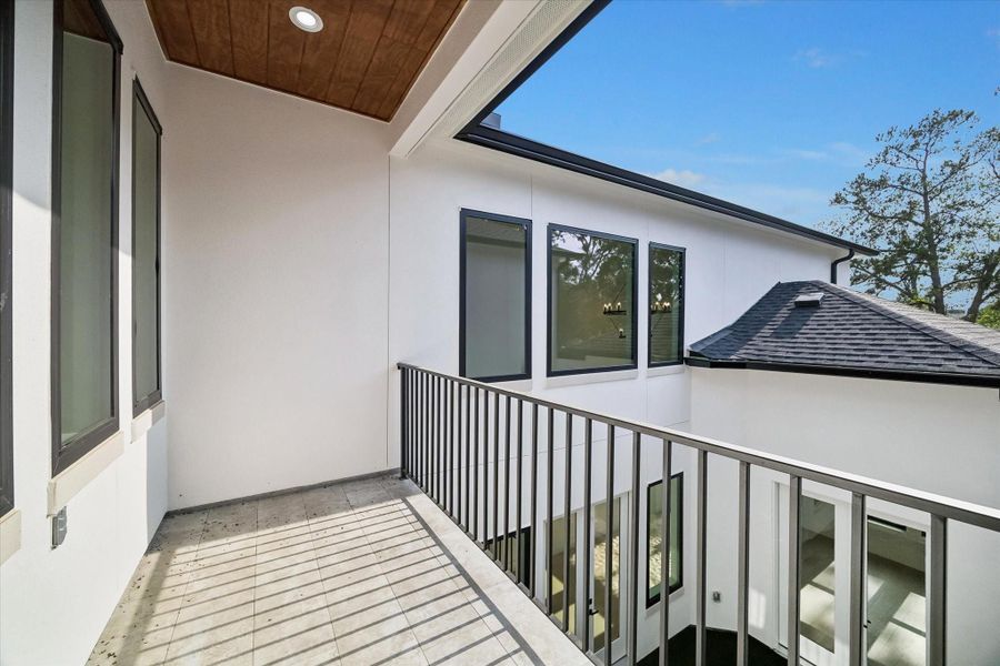 On arrival at the top of the stairs a bridge presents an overlook to the two-story Family Room and takes you across to the Game Room, Media Room and one of the other upstairs secondary bedrooms. An exterior door gives access to the covered and tiled balcony with wood panel ceiling that overlooks the central courtyard below.