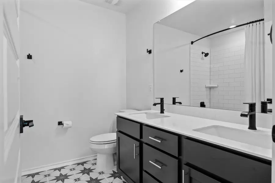 Bathroom with double vanity and tiled shower