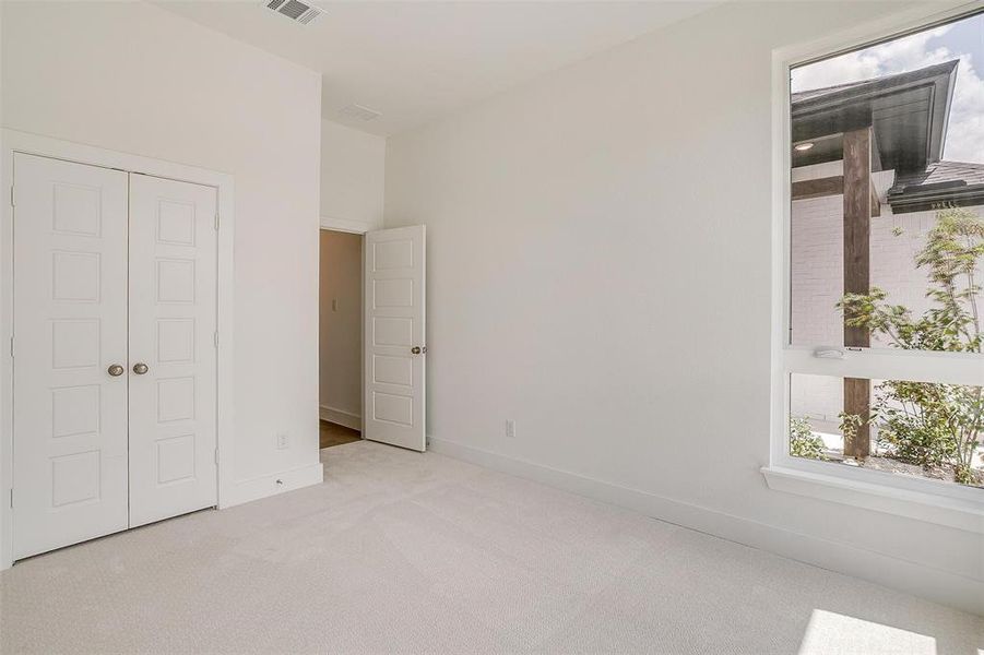 Unfurnished bedroom with light colored carpet and a closet