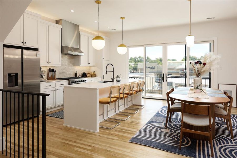 Entertainer's kitchen with stainless steel fridge, tasteful backsplash, decorative lighting, and natural light through sliding patio doors