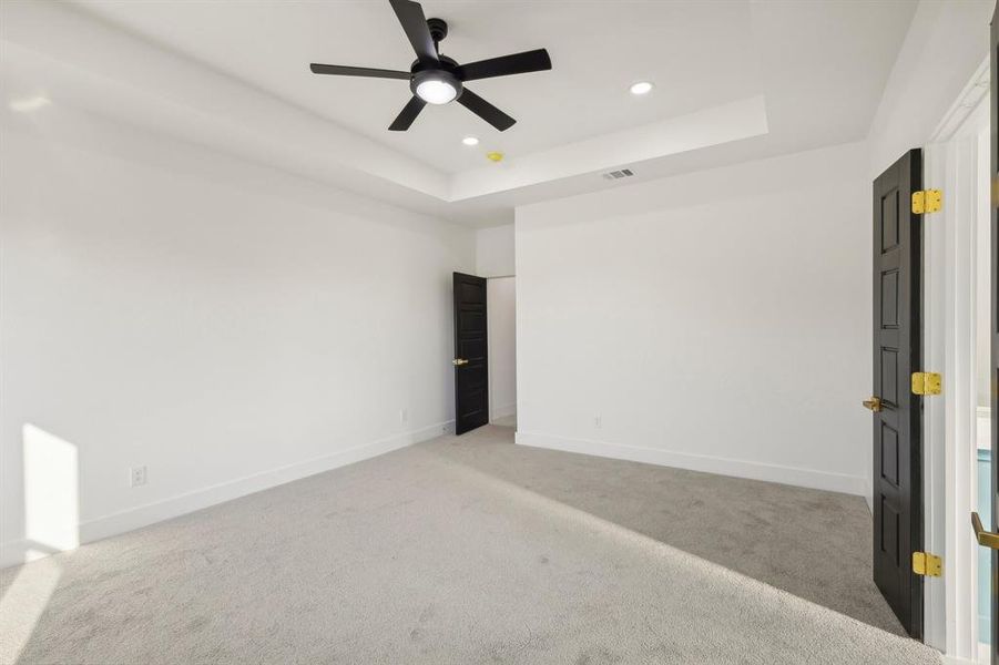 Unfurnished bedroom featuring a tray ceiling, carpet floors, ceiling fan, and recessed lighting Unfurnished bedroom featuring a tray ceiling, carpet floors, ceiling fan, and recessed lighting