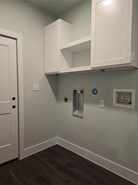 Washroom with dark wood finished floors, hookup for a washing machine, cabinet space, and hookup for an electric dryer