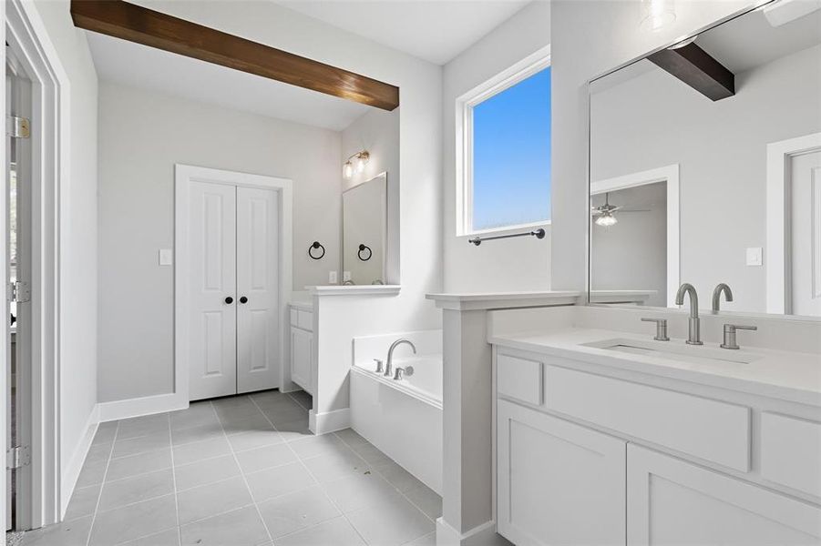 Bathroom featuring a bath, light tile patterned flooring, two vanities, and a ceiling fan Bathroom featuring a bath, light tile patterned flooring, two vanities, and a ceiling fan