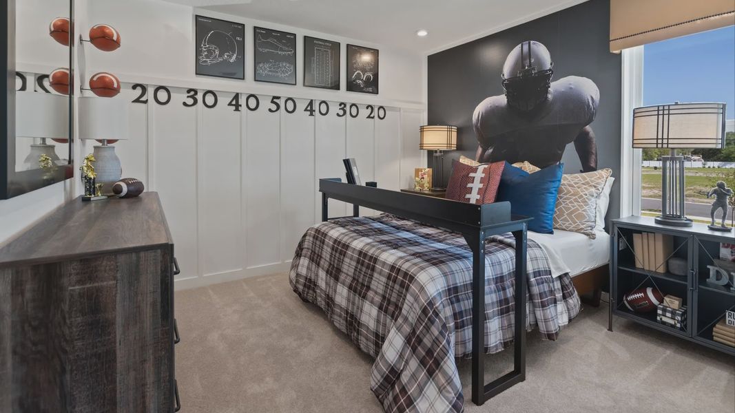 Carpeted secondary bedroom with large window in a DRB Home Clementine model at the Trinity Place community.