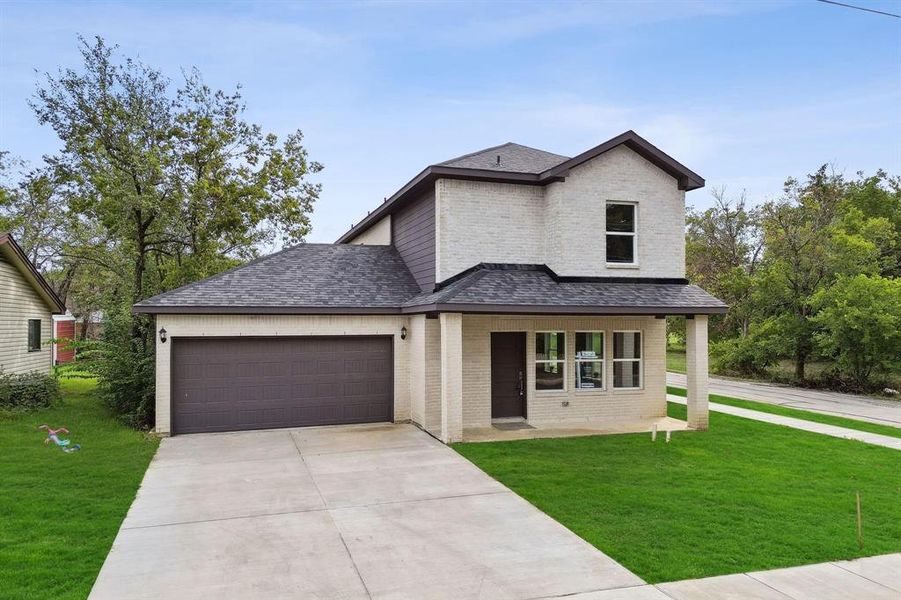 View of front of home featuring a garage, a front lawn, and covered porch