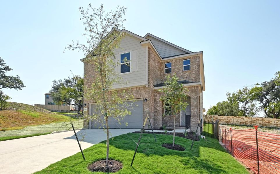 Front exterior of a new home in Creekside at Estancia, Austin, TX, highlighting curb appeal (Image 1).