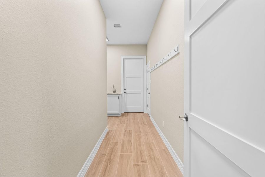 Wide hallway leading to the laundry and storage areas, continuing the home’s bright, open feel.
