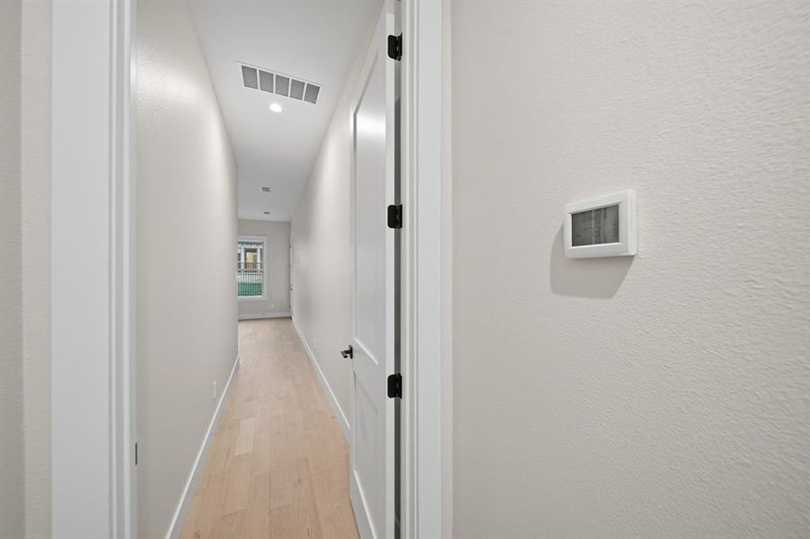 Corridor with light wood finished floors and recessed lighting