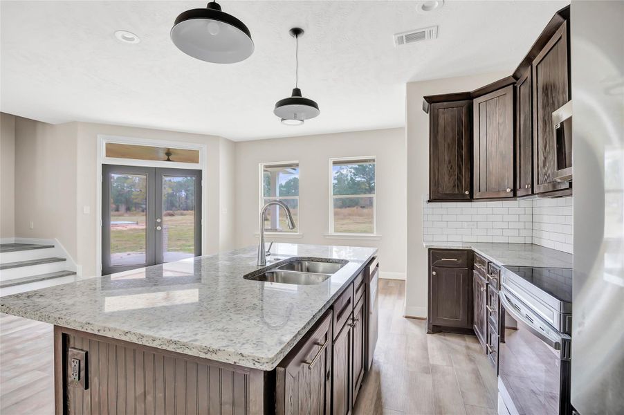 Kitchen view through to the breakfast area and back porch. Love that back yard view!