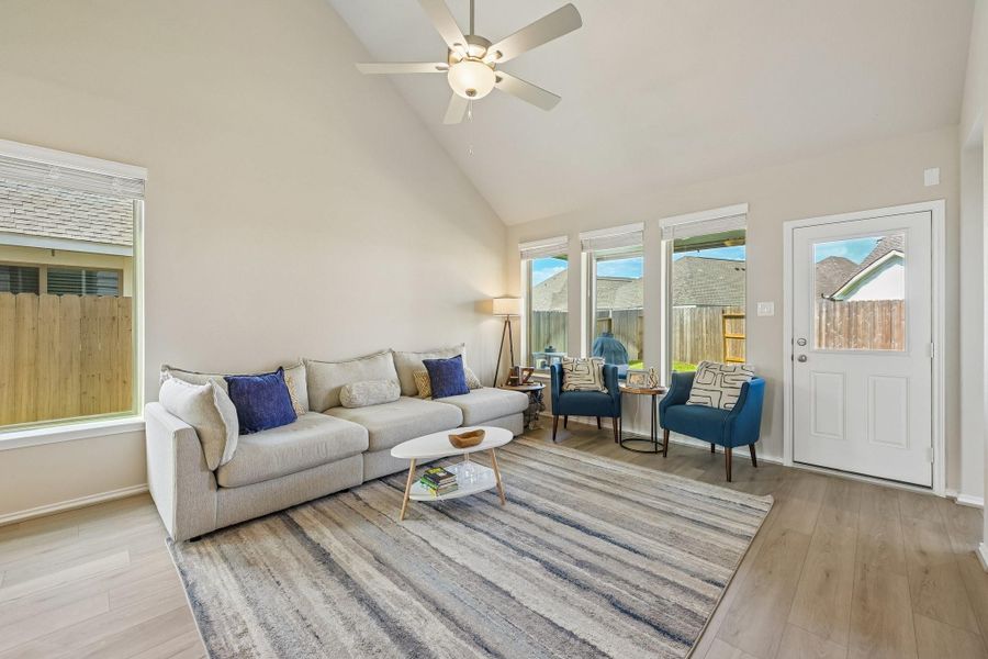 Bright and inviting living room featuring high ceilings, large windows, and elegant wood flooring, perfect for relaxation and entertaining.