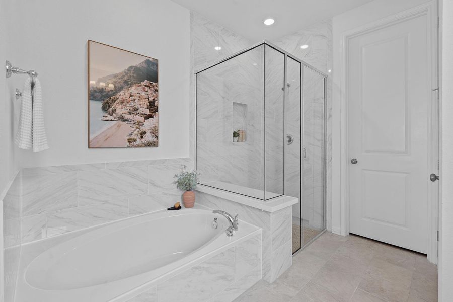 Full bathroom featuring a bath and a marble finish shower