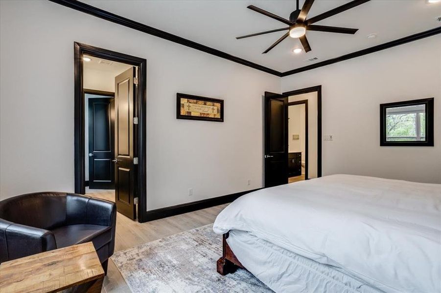 Bedroom featuring ensuite bathroom, light wood-type flooring, ornamental molding, recessed lighting, and a ceiling fan