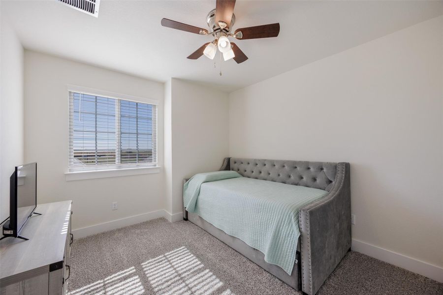Bedroom featuring light colored carpet and ceiling fan Bedroom featuring light colored carpet and ceiling fan