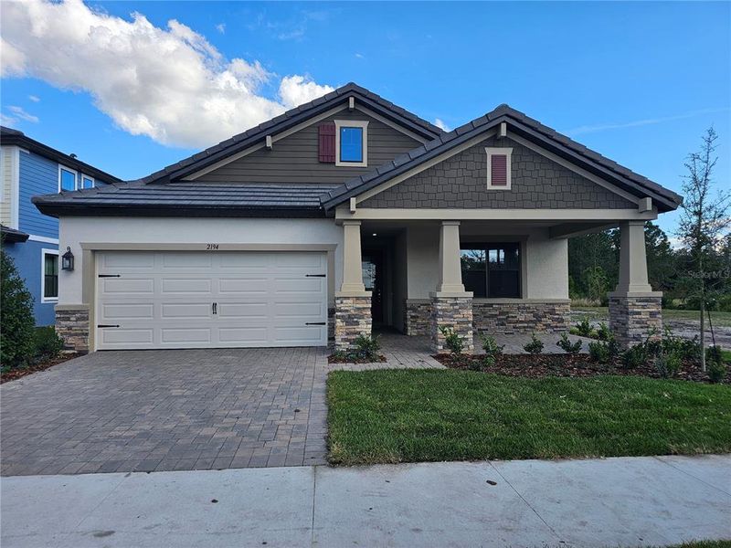 Front exterior of a new home in Tamarack at Two Rivers, Zephyrhills, FL, highlighting curb appeal (Image 2). Front exterior of a new home in Tamarack at Two Rivers, Zephyrhills, FL, highlighting curb appeal (Image 2).