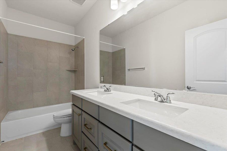 Bathroom with double vanity, tub / shower combination, and light tile patterned flooring Bathroom with double vanity, tub / shower combination, and light tile patterned flooring