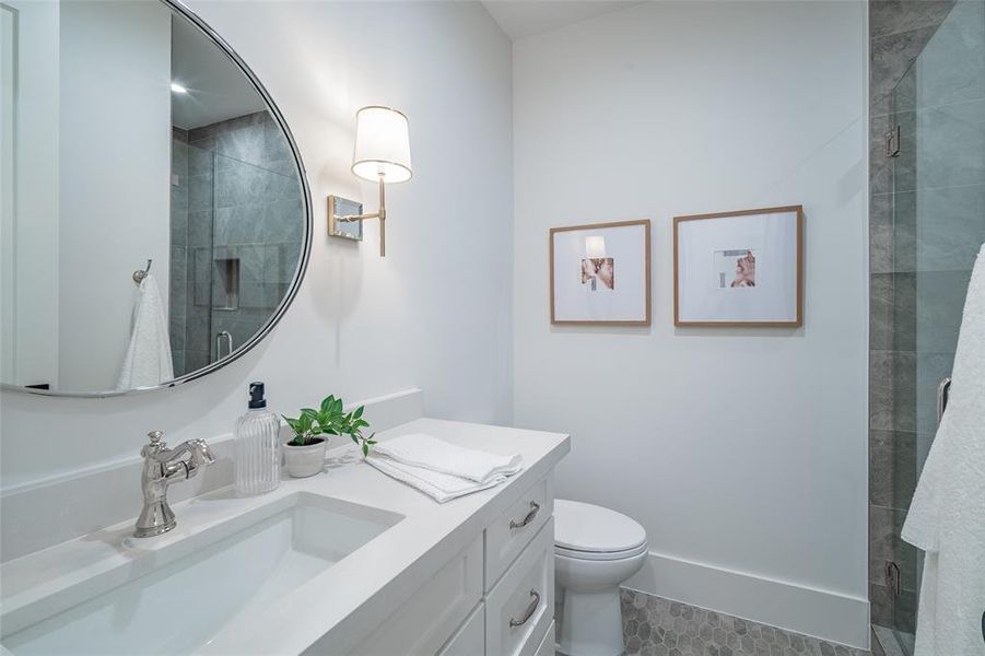 Bathroom featuring tile patterned flooring, vanity, toilet, and an enclosed shower