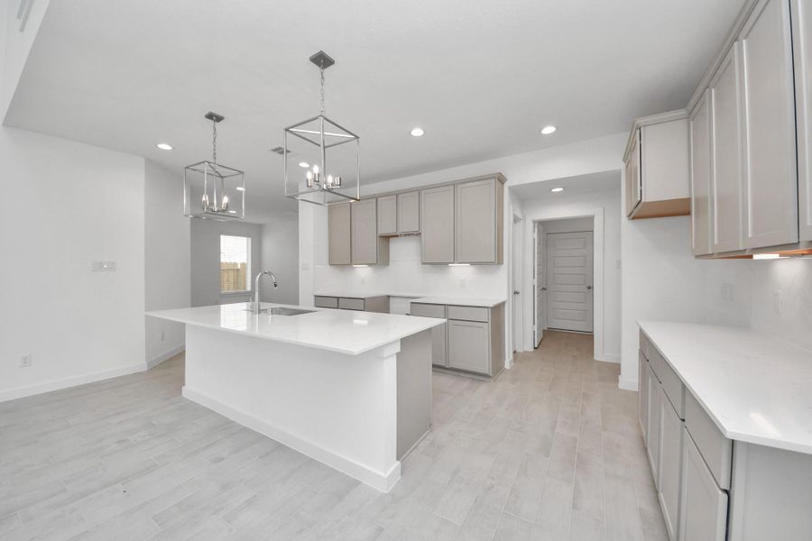 The open concept effortlessly connects the kitchen to the expansive family room, forming a perfect hub for gatherings. This seamless flow creates an inviting space where cooking and socializing come together harmoniously. Sample photo of completed home with similar floor plan. Actual colors and selections may vary.