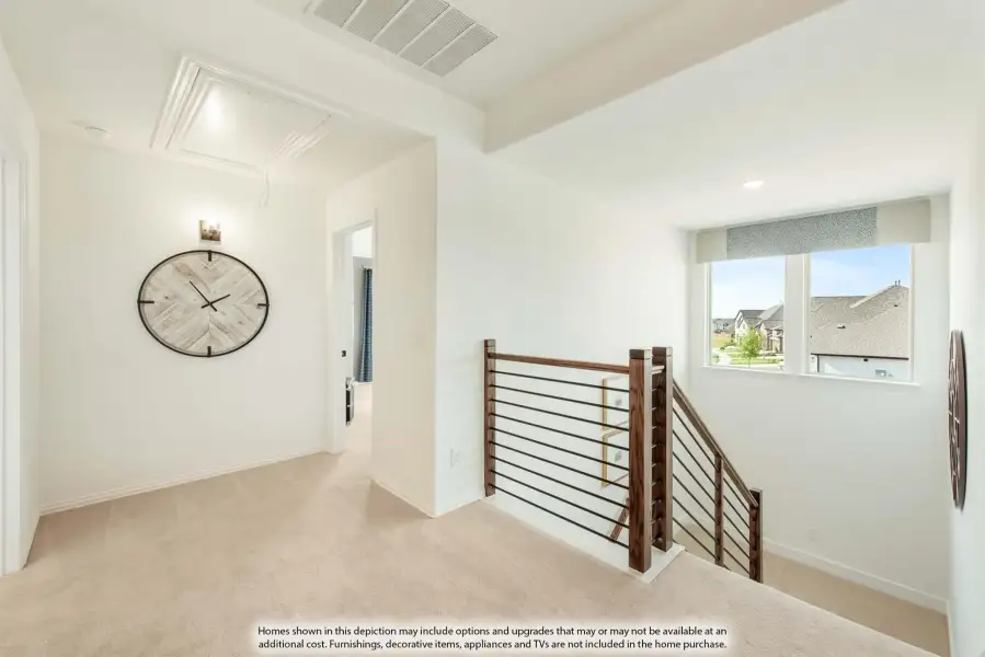 Upstairs hallway with carpet flooring, wood and metal stair railing, and decorative wall clock