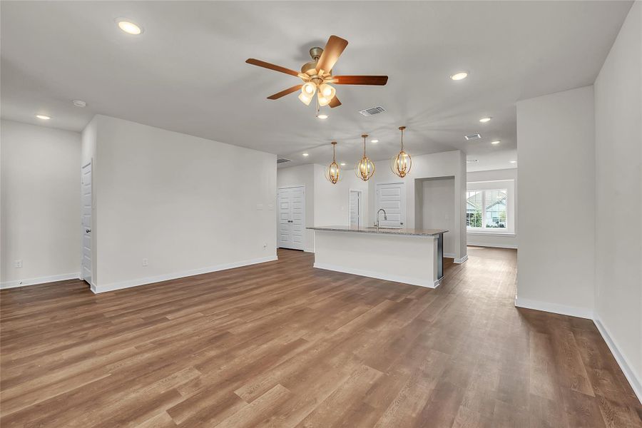 Unfurnished living room featuring recessed lighting, ceiling fan, and dark wood-style floors Unfurnished living room featuring recessed lighting, ceiling fan, and dark wood-style floors