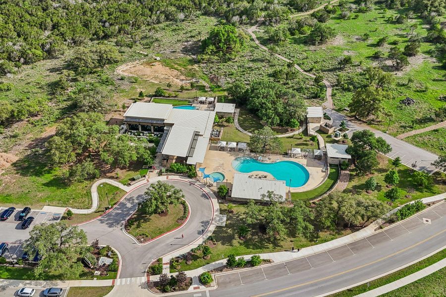 An aerial perspective reveals a vibrant community hub with multiple swimming pools and lush green spaces.
