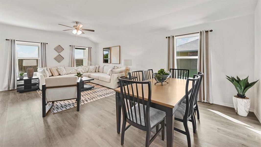 Open concept living area featuring light-colored flooring, white walls, and a ceiling fan