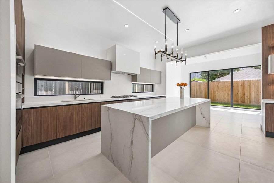 Stunning kitchen with quartzite island. Johnson cabinets by Foscari. Porcelain tile floors. Stunning kitchen with quartzite island. Johnson cabinets by Foscari. Porcelain tile floors.