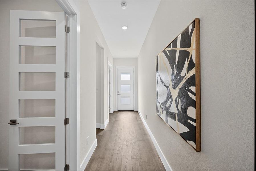 Hall featuring light wood-type flooring and built in features Hall featuring light wood-type flooring and built in features