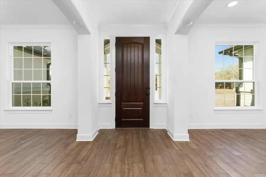 Entrance foyer featuring wood finished floors, baseboards, and crown molding Entrance foyer featuring wood finished floors, baseboards, and crown molding