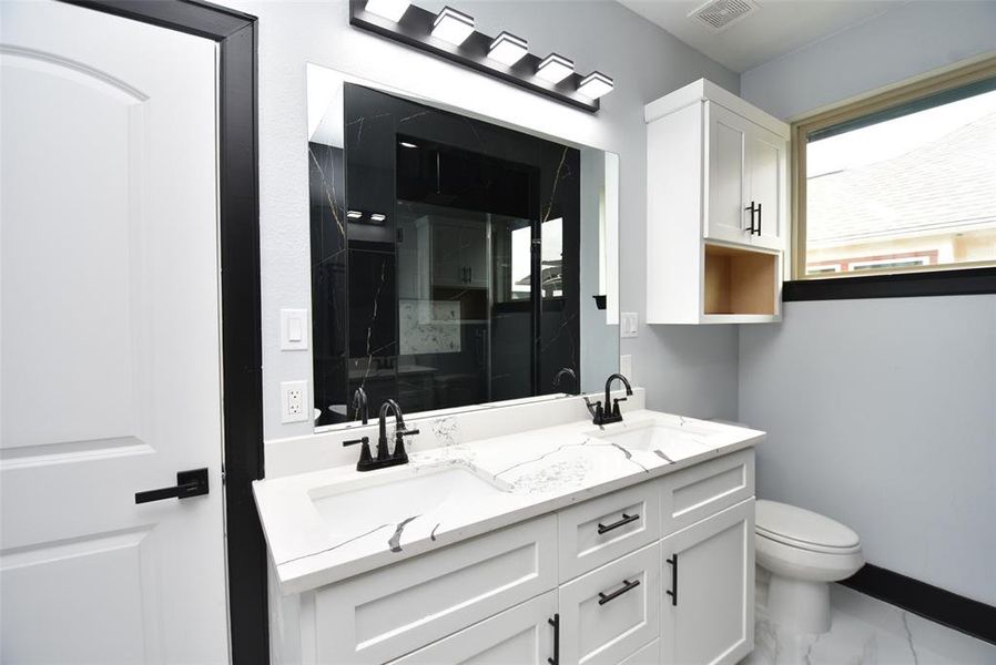 Additionally, it includes an inset shower and tub niche for added functionality. Alongside double sinks, the primary bathroom includes quartz countertops for an extra touch of style.