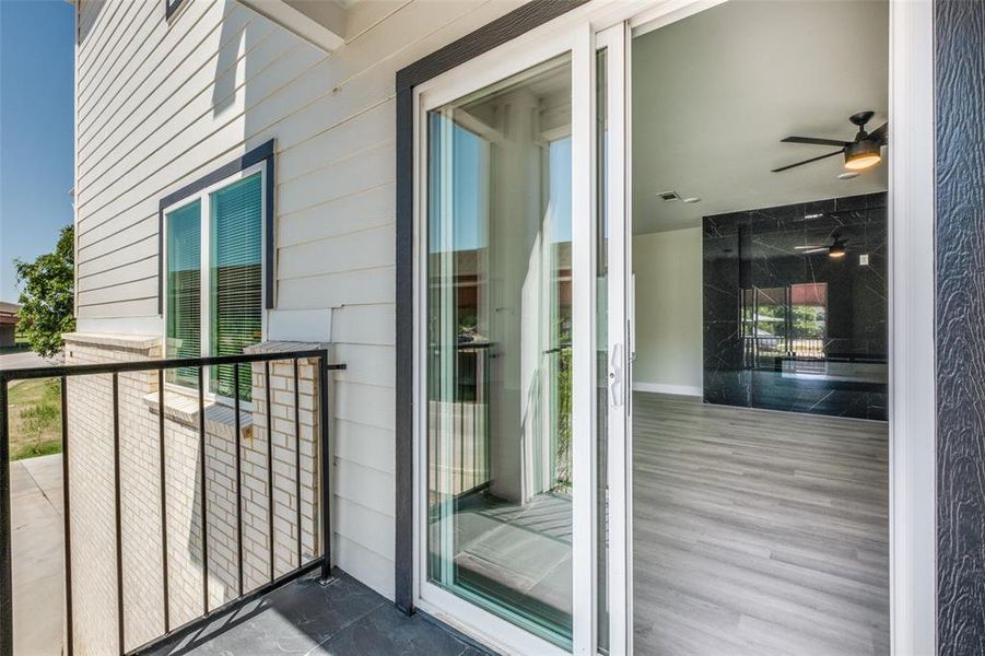 Doorway to property featuring a balcony and a ceiling fan Doorway to property featuring a balcony and a ceiling fan