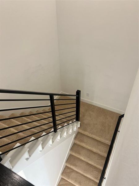 Staircase featuring carpet flooring and baseboards