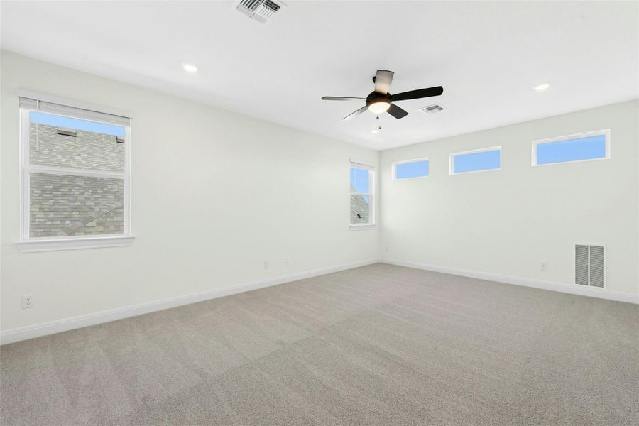Carpeted spare room with plenty of natural light, a ceiling fan, and recessed lighting