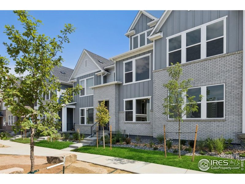 Front exterior of a new home in Kinston Mainstreet Townhomes, Loveland, CO, highlighting curb appeal (Image 27). Front exterior of a new home in Kinston Mainstreet Townhomes, Loveland, CO, highlighting curb appeal (Image 27).