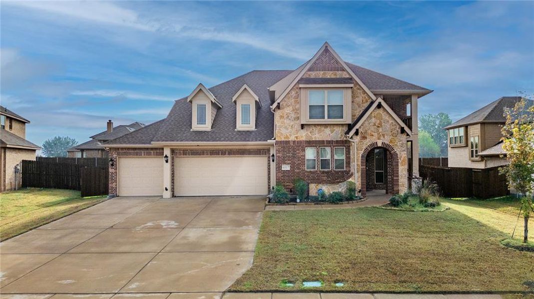 View of front of house featuring driveway, stone siding, roof with shingles, and brick siding View of front of house featuring driveway, stone siding, roof with shingles, and brick siding