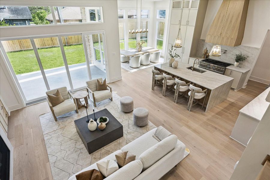 This view really shows off the heart of the home, with 12-foot ceilings, engineered white oak flooring, Visual Comfort lighting and walls of windows creating a bright, open setting for everyday living and entertaining. Folding glass doors extend the space to the covered outdoor kitchen, while Taj Mahal surfaces, Thermador appliances, a hidden pantry, mud room, study or 5th bedroom, plus a full bath and powder bath downstairs make the layout as practical as it is beautiful.