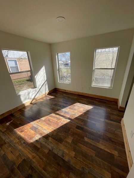 Spare room with dark wood finished floors and baseboards