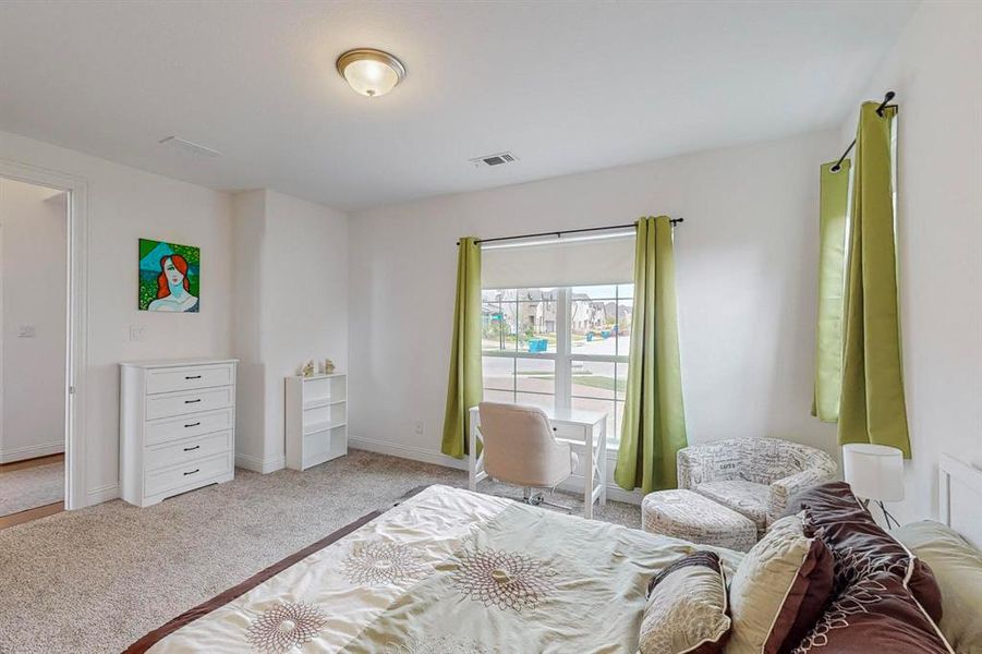 Secondary Bedroom located nearest entry. The large windows provide plenty of natural light and allows the option of turning this into an office, playroom, or activity room.