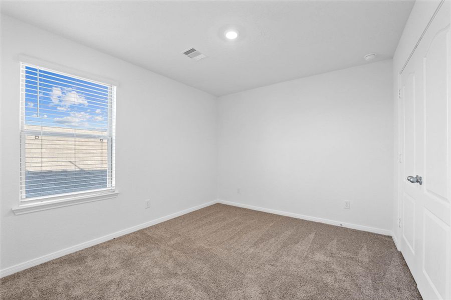 This secondary bedroom offers comfort and style with plush carpeting, neutral paint tones, recessed lighting, a large window with blinds, and a generously sized closet. This secondary bedroom offers comfort and style with plush carpeting, neutral paint tones, recessed lighting, a large window with blinds, and a generously sized closet.