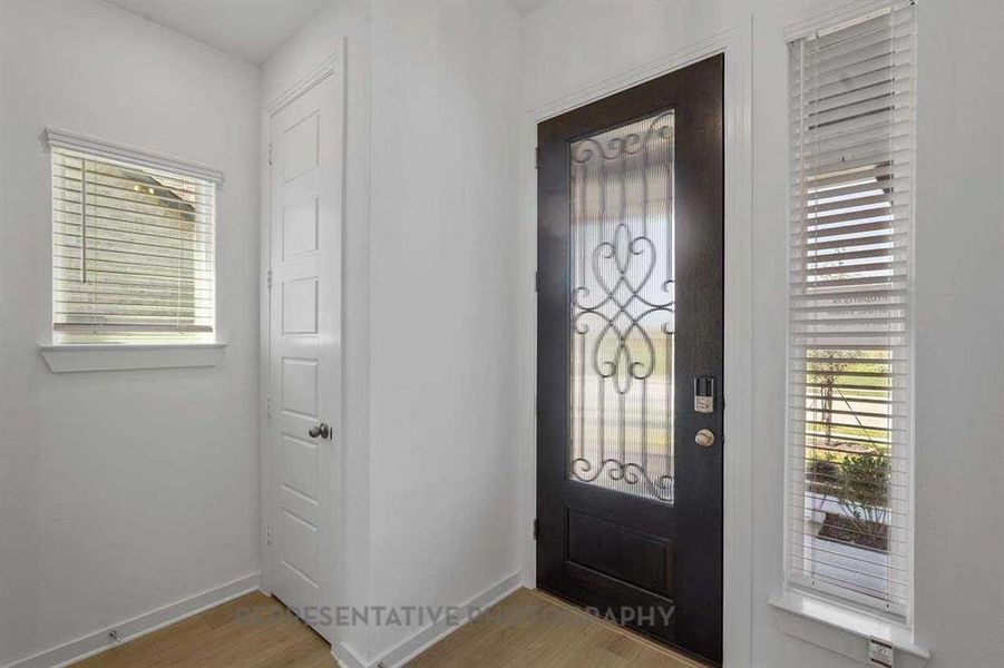 Foyer entrance with light wood-type flooring and baseboards